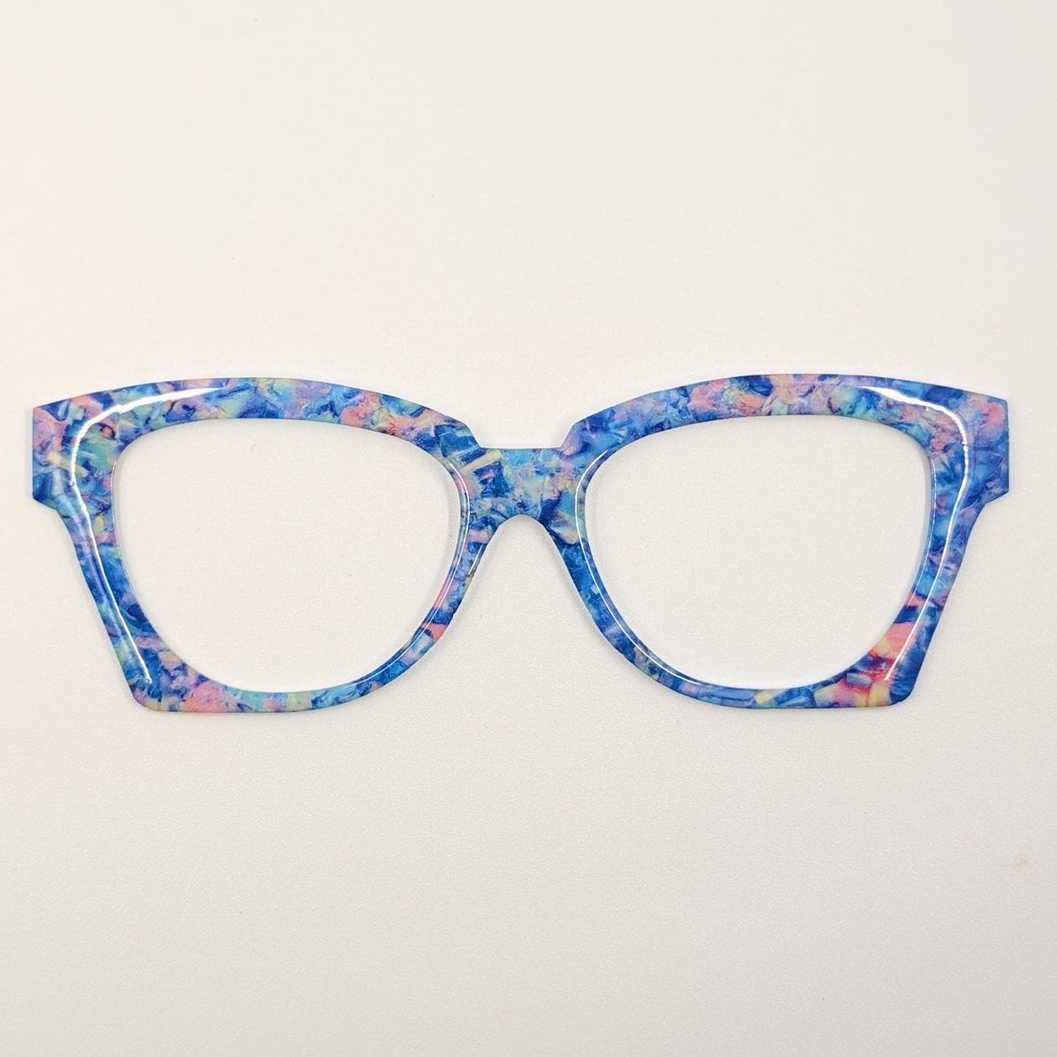 Cat-eye style eyeglasses with a vibrant blue, pink, and purple marbled pattern, shown against a plain white background.