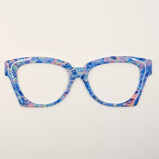 Cat-eye style eyeglasses with a vibrant blue, pink, and purple marbled pattern, shown against a plain white background.