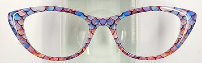 Cute cat-eye eyeglasses with a colorful mosaic patterned frame, displayed on a clear acrylic stand against a plain white background.