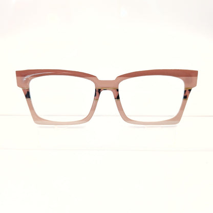 A pair of cat-eye style eyeglasses with a translucent dusty rose pink frame and clear lenses, displayed against a clean white background.
