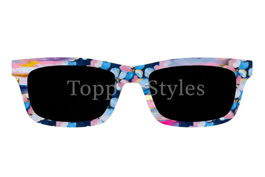 A pair of oversized square sunglasses with a vibrant multicolor floral and abstract paint-stroke pattern on the arms, shown against a plain white background.